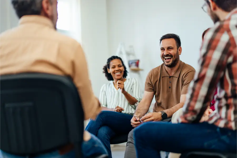 Man having fun conversation with others while Cognitive Behavioral Group Therapy at Transformation Health Services in Virginia Beach, VA