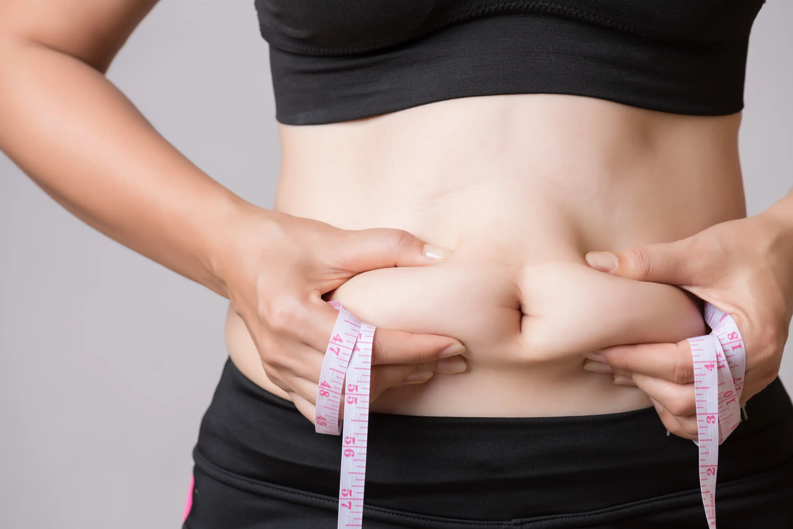 A Woman holding her waist fat and worried for weight | Medical Weight Management at Transformation Health Services